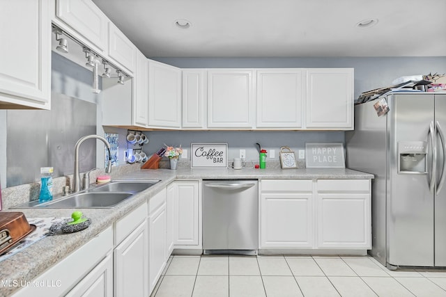 kitchen with stainless steel appliances, sink, light tile patterned floors, and white cabinets