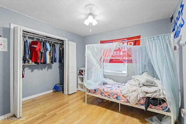 bedroom featuring hardwood / wood-style floors, a textured ceiling, and a closet