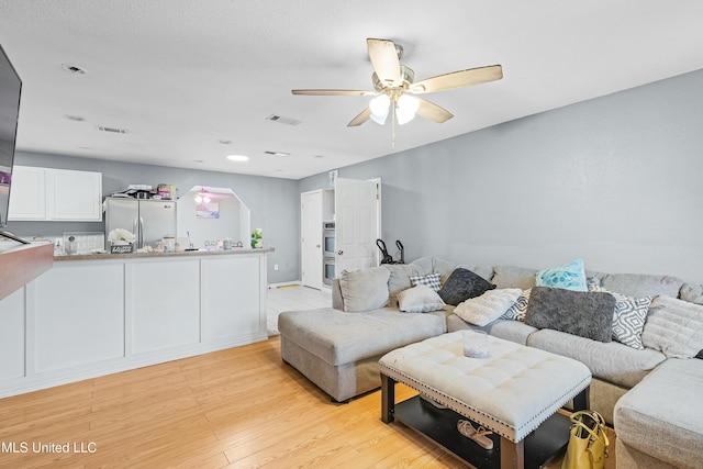 living room with ceiling fan and light hardwood / wood-style floors