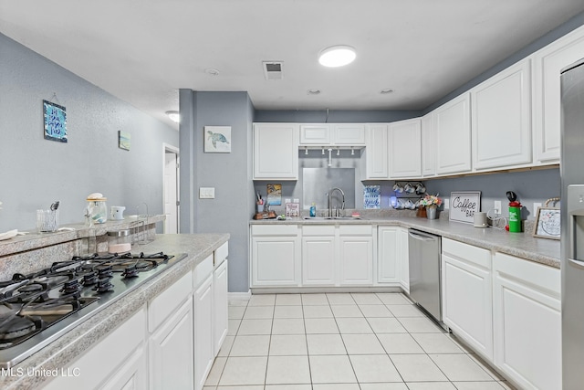 kitchen featuring sink, light tile patterned flooring, white cabinets, and appliances with stainless steel finishes