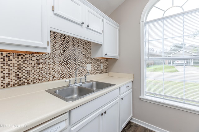 kitchen featuring white cabinets, decorative backsplash, a healthy amount of sunlight, and sink