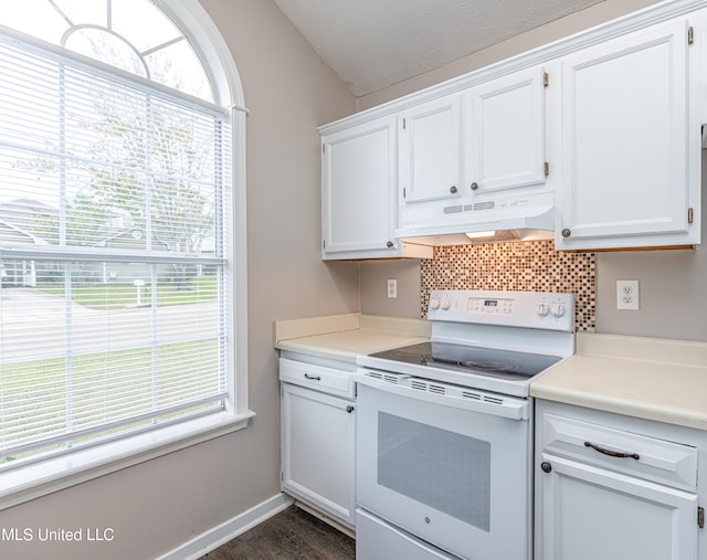 kitchen with tasteful backsplash, white range with electric cooktop, white cabinets, and vaulted ceiling