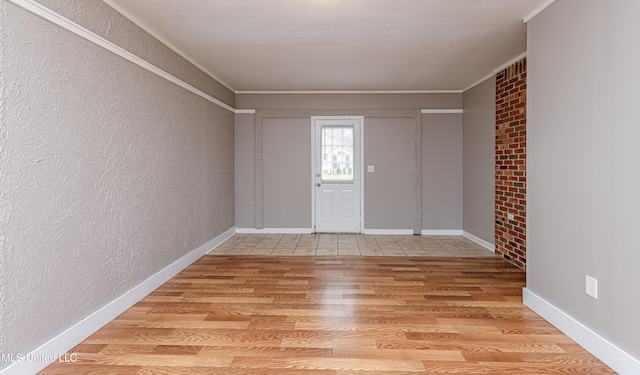 foyer with light wood-type flooring and ornamental molding