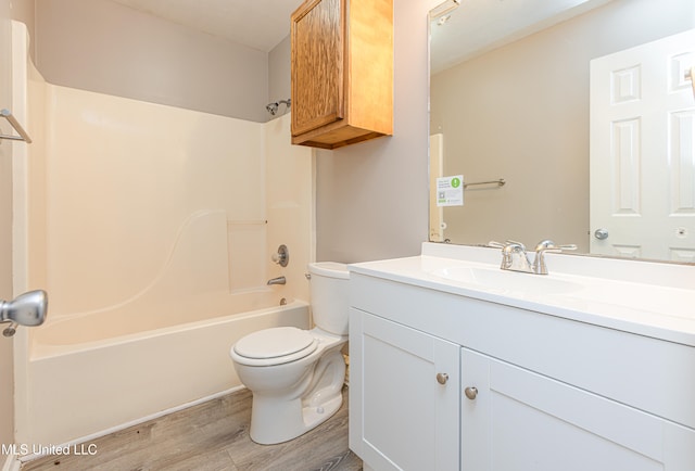 full bathroom with hardwood / wood-style flooring, vanity, toilet, and shower / tub combination