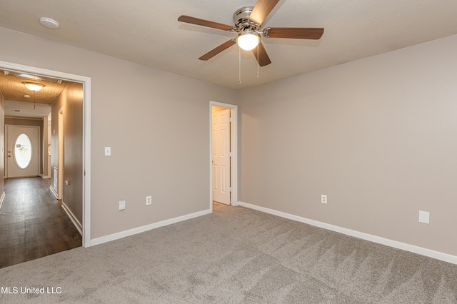 empty room featuring ceiling fan and carpet