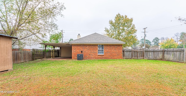 back of house with a yard and central AC