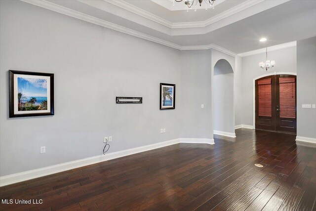 unfurnished room featuring french doors, dark hardwood / wood-style flooring, an inviting chandelier, and ornamental molding