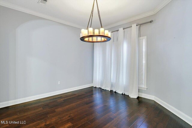 spare room with dark hardwood / wood-style flooring, ornamental molding, and a notable chandelier