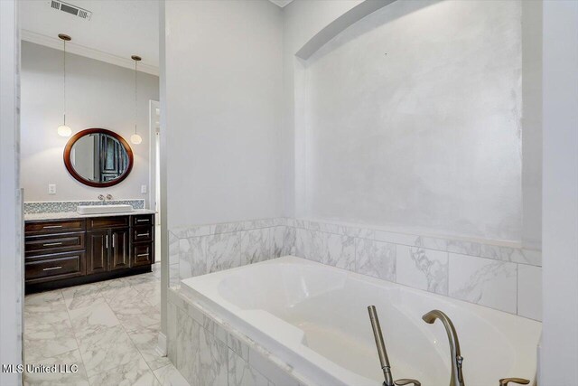 bathroom featuring vanity, a relaxing tiled tub, and crown molding