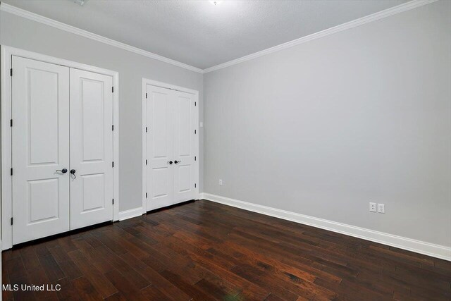 unfurnished bedroom featuring crown molding, dark wood-type flooring, and a textured ceiling