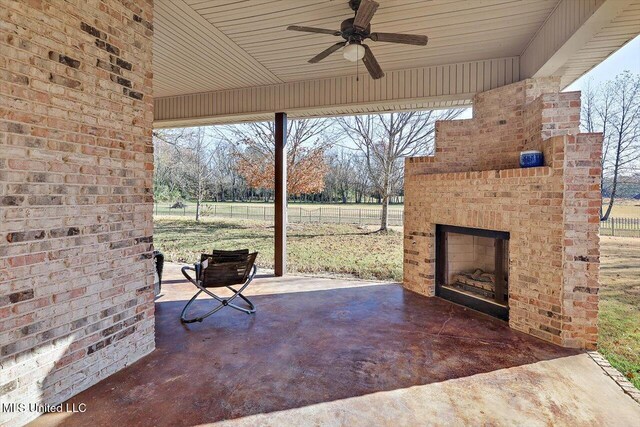 view of patio featuring an outdoor brick fireplace and ceiling fan