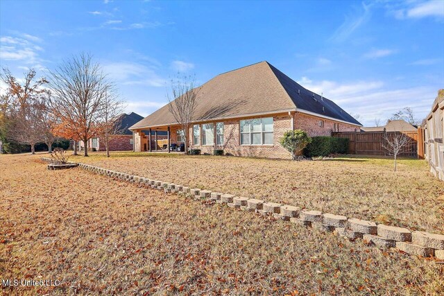 rear view of property featuring a lawn