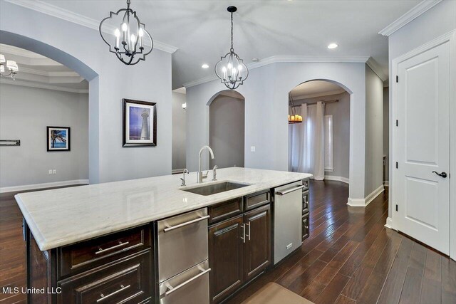 kitchen with dark brown cabinetry, sink, dark wood-type flooring, a kitchen island with sink, and ornamental molding