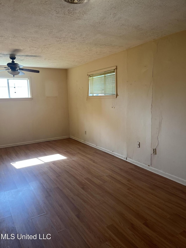 spare room featuring baseboards, a ceiling fan, a textured ceiling, and wood finished floors