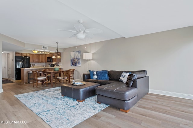 living room with light hardwood / wood-style floors and ceiling fan