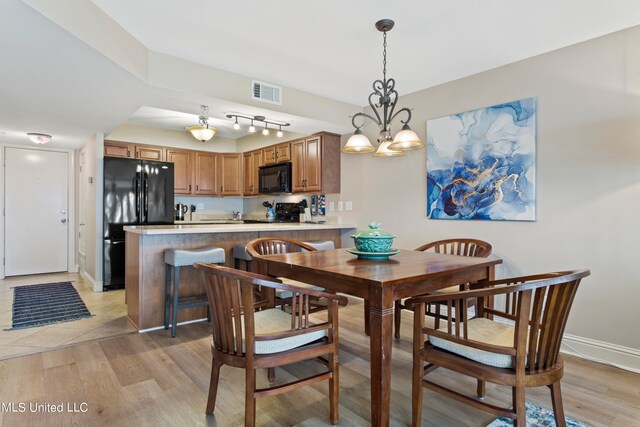 dining room featuring a notable chandelier and light wood-type flooring