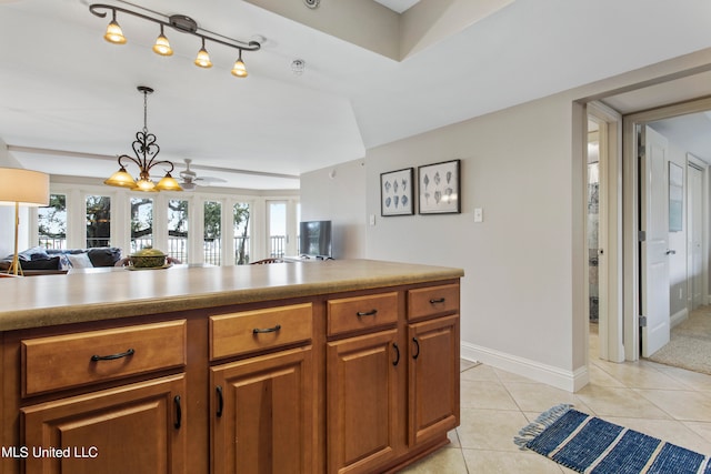 kitchen featuring french doors, light tile patterned flooring, pendant lighting, and ceiling fan with notable chandelier