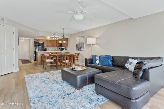 living room with light hardwood / wood-style floors and ceiling fan