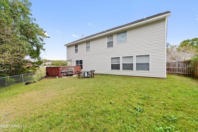 back of property with a yard and a deck