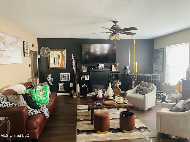 living room featuring a textured ceiling, ceiling fan, and dark hardwood / wood-style floors