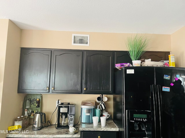 kitchen featuring black refrigerator with ice dispenser