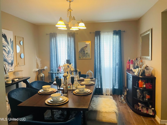 dining area with dark hardwood / wood-style flooring and a chandelier