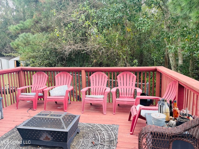 wooden terrace featuring an outdoor fire pit