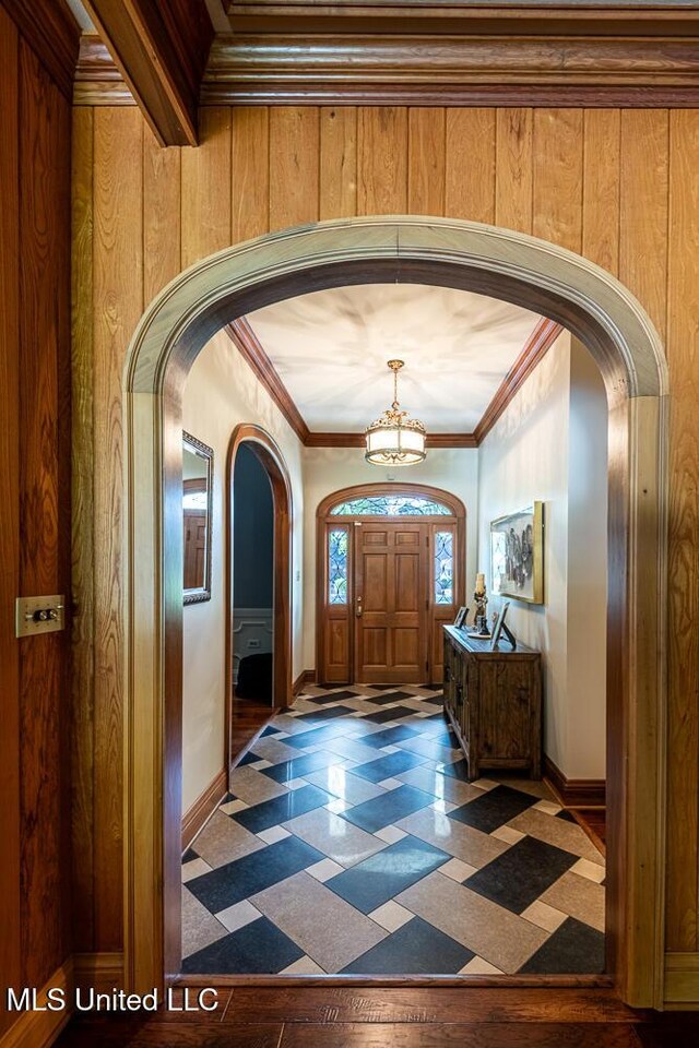 305 Creekbend Rd, Natchez, MS 39120 - foyer entrance featuring arched walkways, a chandelier, wooden walls, ornamental molding, and tile patterned floors