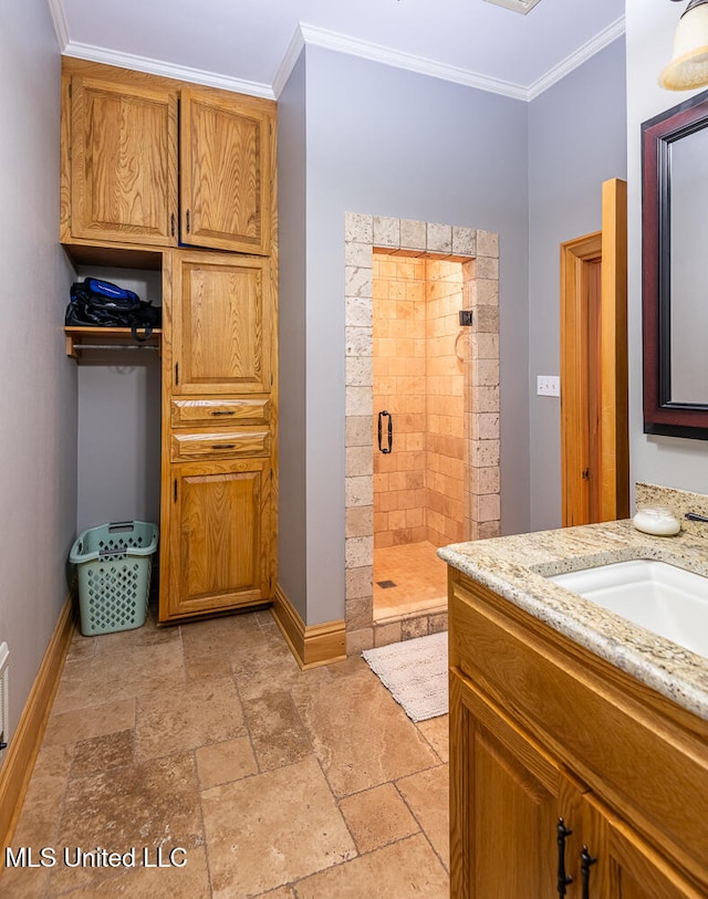 bathroom featuring a shower with shower door, vanity, and ornamental molding