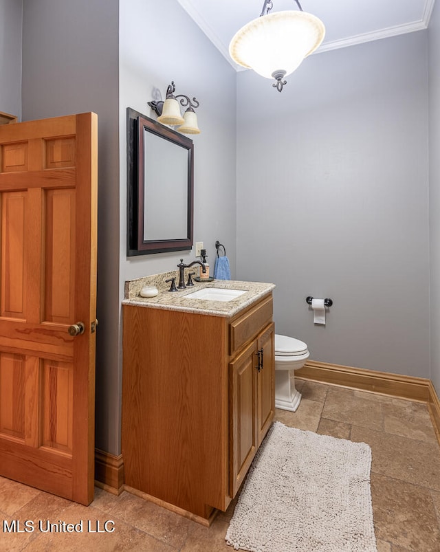 bathroom with ornamental molding, vanity, and toilet