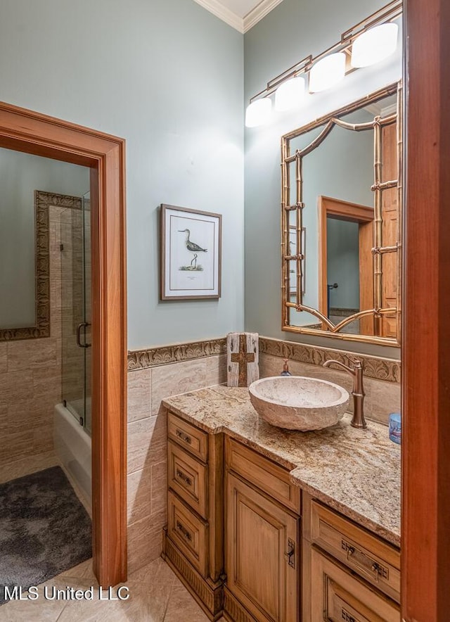 305 Creekbend Rd, Natchez, MS 39120 - bathroom with tile patterned floors, ornamental molding, vanity, tile walls, and combined bath / shower with glass door