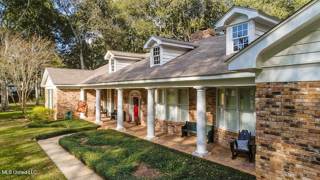 305 Creekbend Rd, Natchez, MS 39120 - back of house with a porch, brick siding, a shingled roof, a lawn, and a chimney