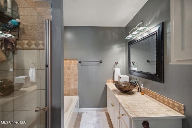 bathroom with an enclosed shower, vanity, a bathtub, and baseboards