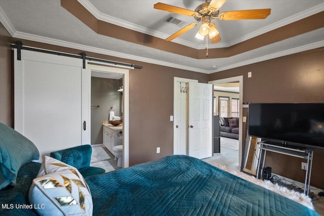 bedroom featuring a barn door, a raised ceiling, carpet, ornamental molding, and a ceiling fan