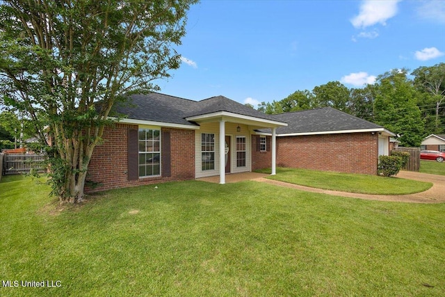 view of front facade with brick siding, a shingled roof, and a patio