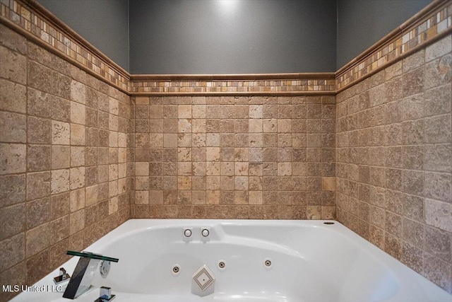 bathroom with tile walls and a jetted tub