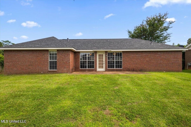 rear view of house with a lawn and brick siding