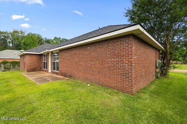 view of property exterior with a patio, brick siding, and a lawn
