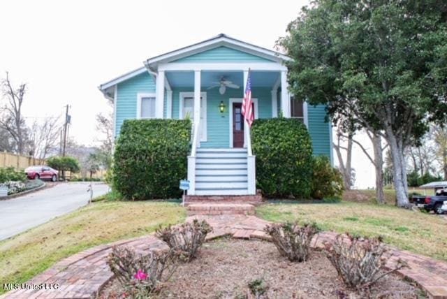 view of front of property featuring a porch, ceiling fan, stairway, and a front lawn