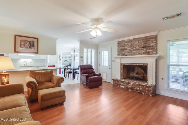 1 Partridge Pl, Long Beach, MS 39560 - living area with ceiling fan, wood finished floors, plenty of natural light, a brick fireplace, and crown molding