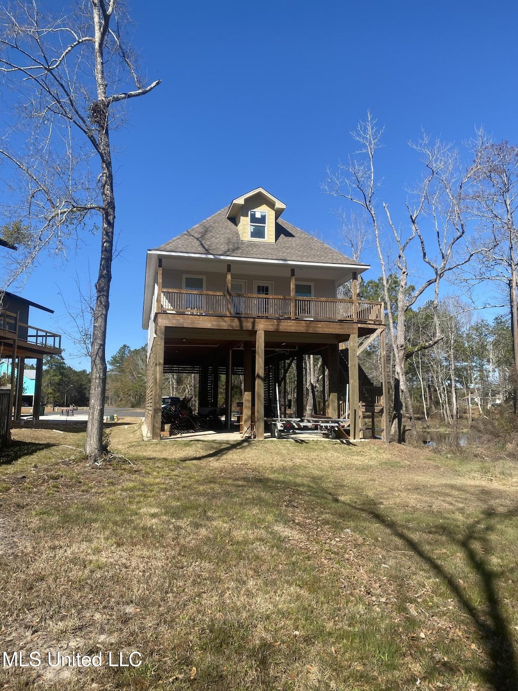 view of front of house with a deck and a front lawn