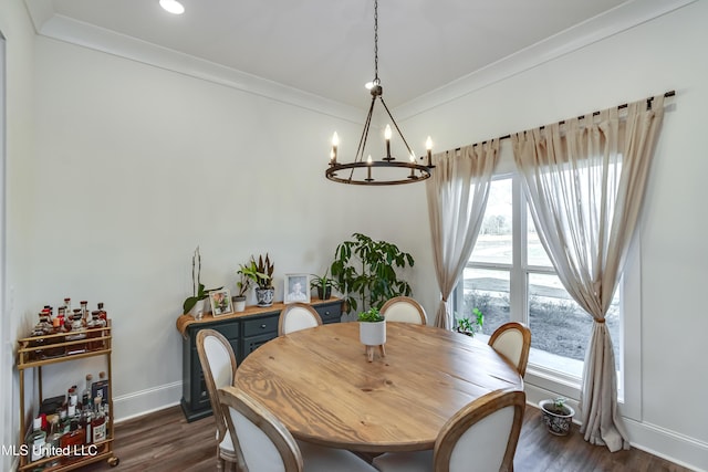 dining area with crown molding, dark hardwood / wood-style floors, and an inviting chandelier