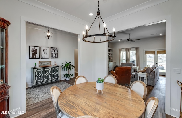 dining room with dark wood-type flooring, ornamental molding, and ceiling fan