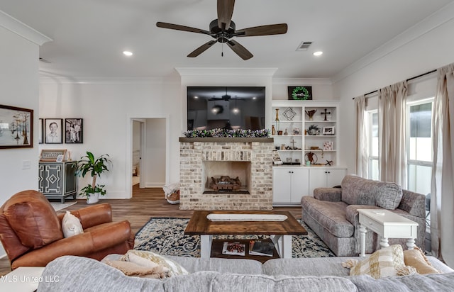 living room with hardwood / wood-style floors, crown molding, and a fireplace