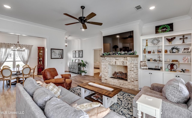 living room featuring a fireplace, ornamental molding, and light wood-type flooring