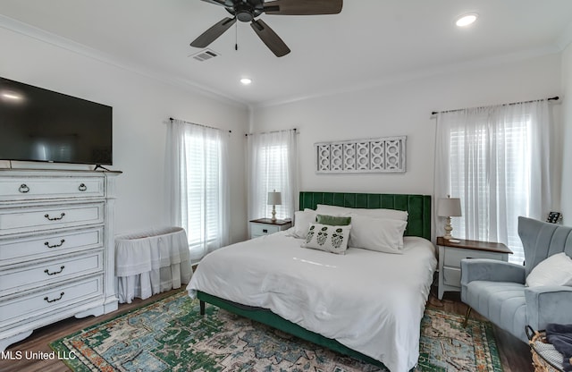 bedroom with ceiling fan, ornamental molding, and dark hardwood / wood-style flooring