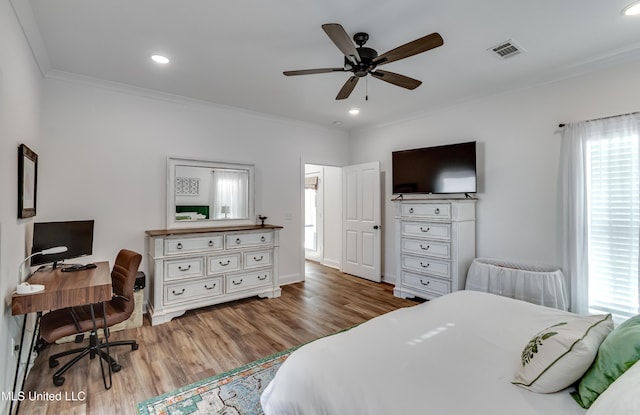 bedroom with wood-type flooring, ornamental molding, and ceiling fan