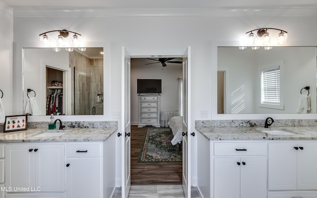 bathroom featuring crown molding, ceiling fan, hardwood / wood-style floors, vanity, and a shower with shower door