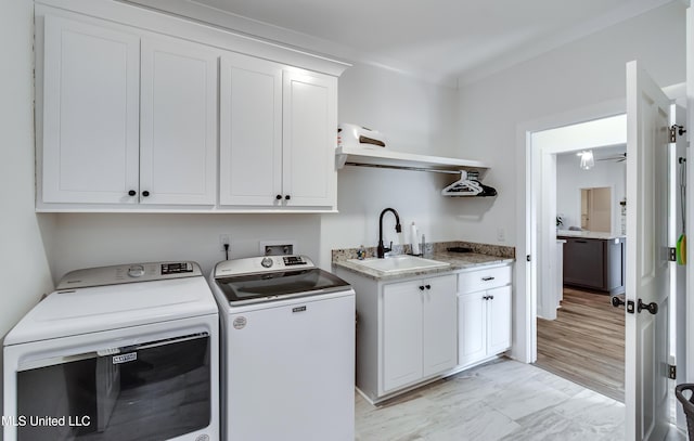 laundry area featuring cabinets, separate washer and dryer, and sink