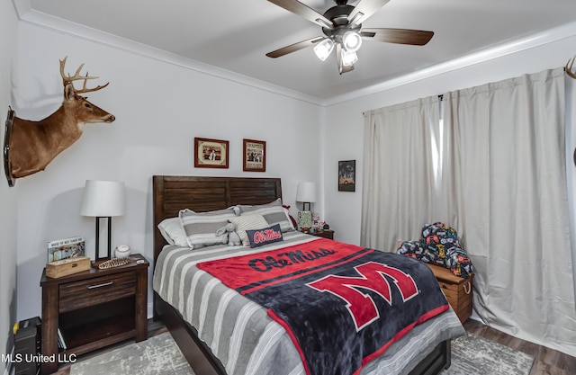 bedroom with crown molding, hardwood / wood-style floors, and ceiling fan